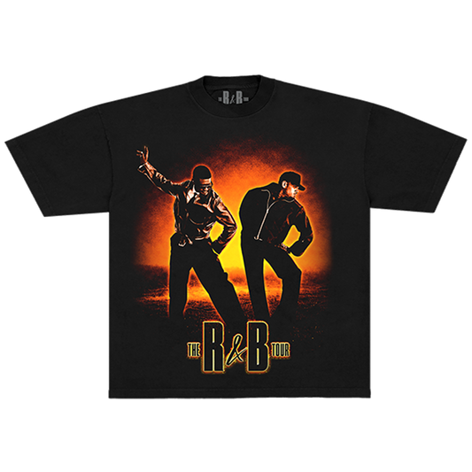 A black short-sleeve graphic t-shirt featuring a stylized print of two men dancing against an orange and yellow sunset background, with the text 'THE R&B TOUR' printed below.